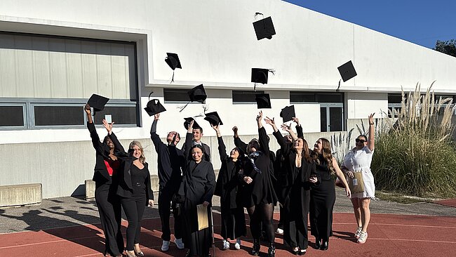 Un groupe d'étudiants jete des chapeaux en l'air