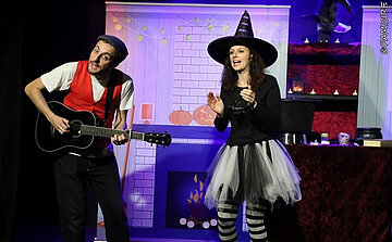 Photo du spectacle Anna Kadabra  - femme en sorcière et homme avec une guitare  
