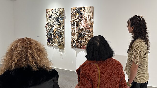 trois femmes regardent un tableau