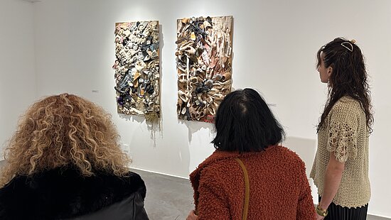 trois femmes regardent un tableau