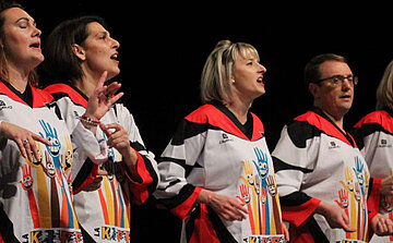 hommes et femme qui font du théâtre d'impro avec tee shirts identique blanc et rouge s