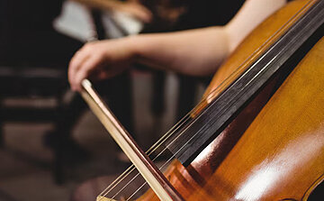Photo de violoncelle main de femme sur archet 