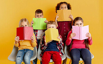 photo d'enfants cachés derrière un livre