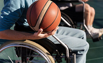 photo de garçon sur fauteuil roulant avec ballon de basket