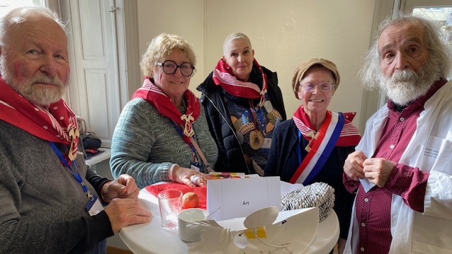 Un groupe de cinq personnes, 3 hommes et 2 femmes, autour d'une table haute