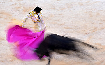 Photo avec effet  mouvement toro et toréro dans arènes cape rose 