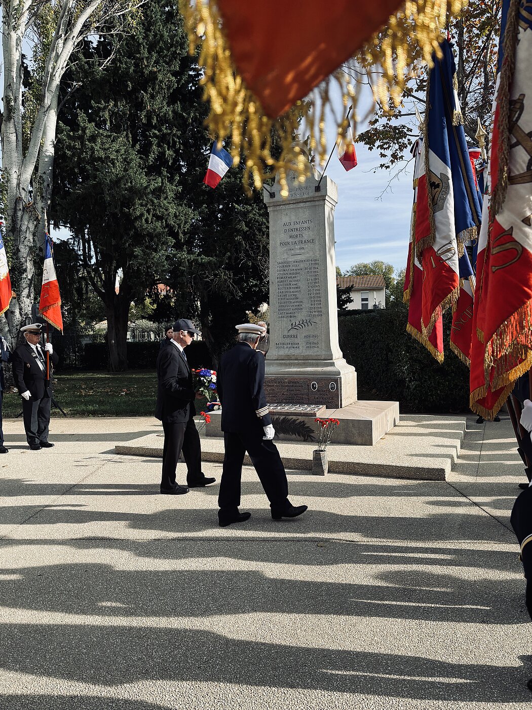 Deux hommes en tenue militaire dépose une gerbe de fleurs