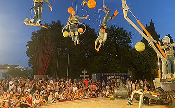 photo de spectacle plein air avec hommes volants dans structure en métal 