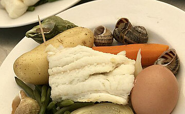 photo d'aioli morceaux de morrue patates carottes escargots haricots verts  