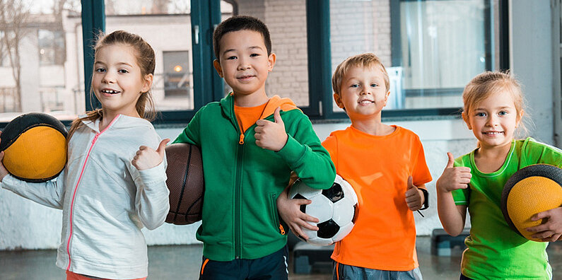 groupe d'enfants 8/10 ans avec ballon de sport - basket, foot, volley
