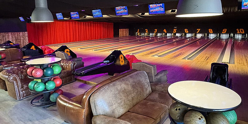 Photo de piste de bowling avec écrans canapé, boules