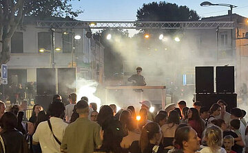 photo de concert en extérireur avec scène foule et fumée 