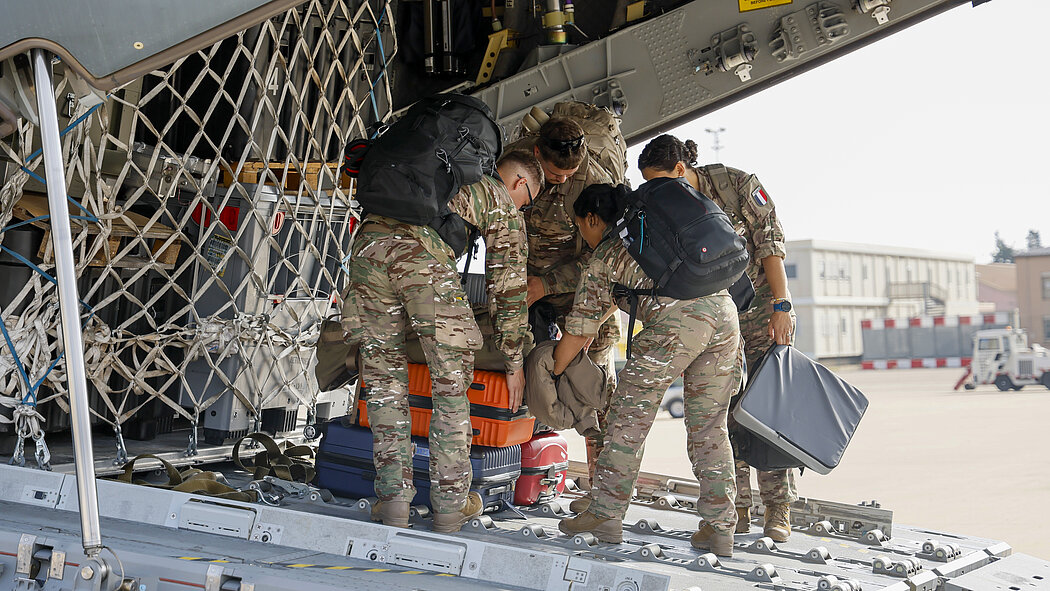 Militaires qui chargent un avion de transport