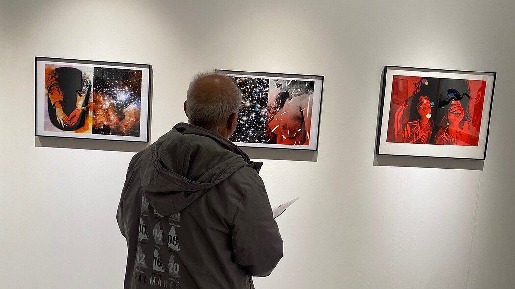 Un homme regarde une série de trois tableaux