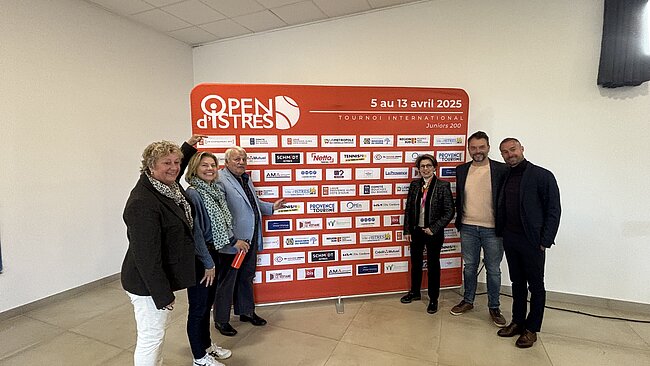 6 personnes devantun tableau de sponsor