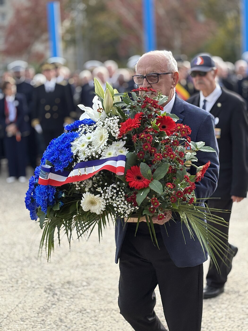 Un homme dépose une gerbe de fleurs