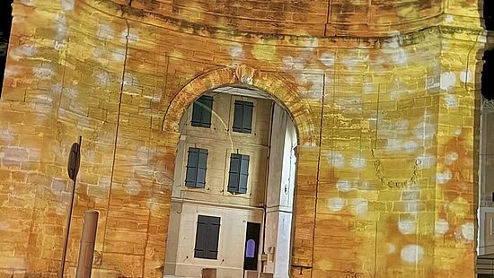 Le portail d'Arles éclairé en orange