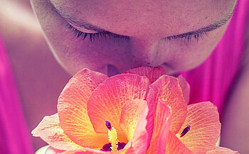 photos de femme qui respire l'odeur d'une fleur 
