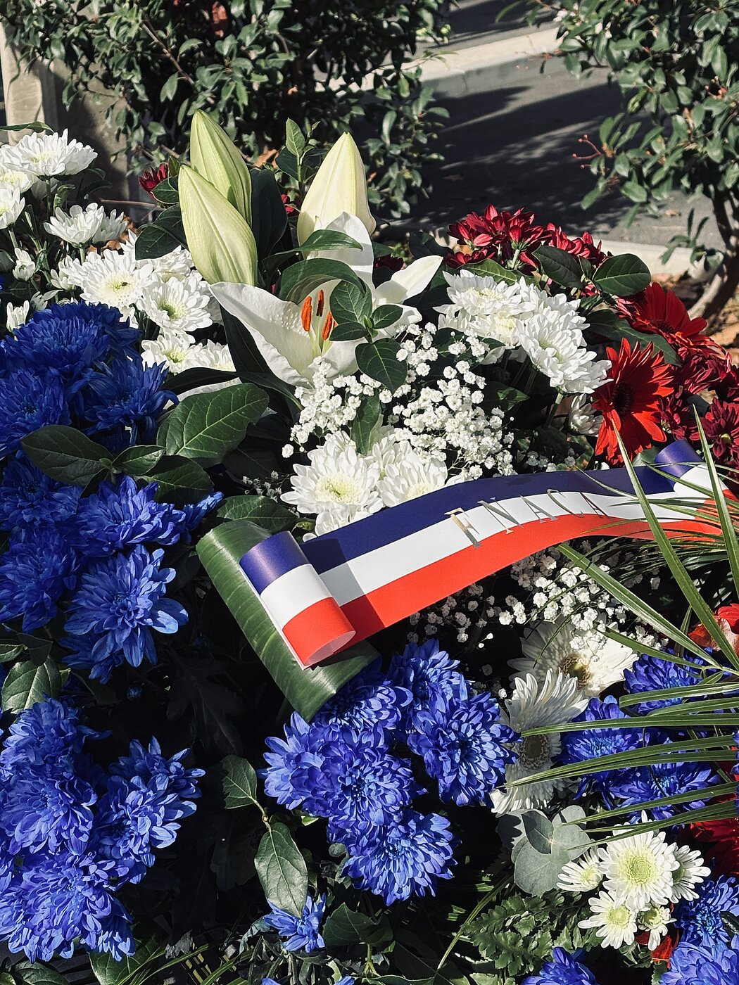 Une gerbe de fleurs avec un bandeau tricolore