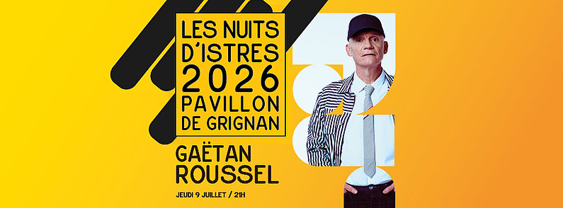 Photo de Gaetan Roussel On voit une personne photographiée en pied jusqu’au haut des cuisses, debout face à l’appareil. Elle porte une casquette noire.  Elle est vêtue d’une chemise blanche, d’une cravate claire avec de fines bandes colorées, et d’une veste à manches longues à rayures verticales noires et blanches.  Le pantalon est foncé. Les mains sont placées dans les poches du pantalon.  Le visage est visible, sans barbe. Le regard est dirigé vers l’avant.  Le fond de l’image est uni et très clair, proche du blanc ou du bleu très pâle, sans élément visible. L’éclairage est uniforme, sans ombre marquée.