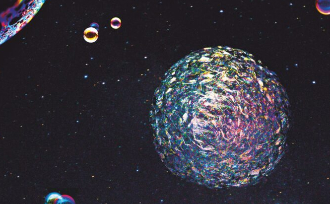 L’image montre une composition visuelle représentant un fond sombre parsemé de petits points lumineux rappelant des étoiles. Au centre, une grande sphère texturée et multicolore occupe une place proéminente. Elle présente des reflets irisés et une surface complexe. Plusieurs petites bulles ou sphères colorées flottent autour, créant un effet spatial ou cosmique. L’ensemble de l’image évoque un environnement abstrait ou inspiré de l’espace.