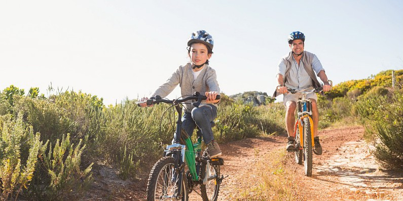 photo d'enfants 8/10 ans en vélo sur chemin  avec papa 